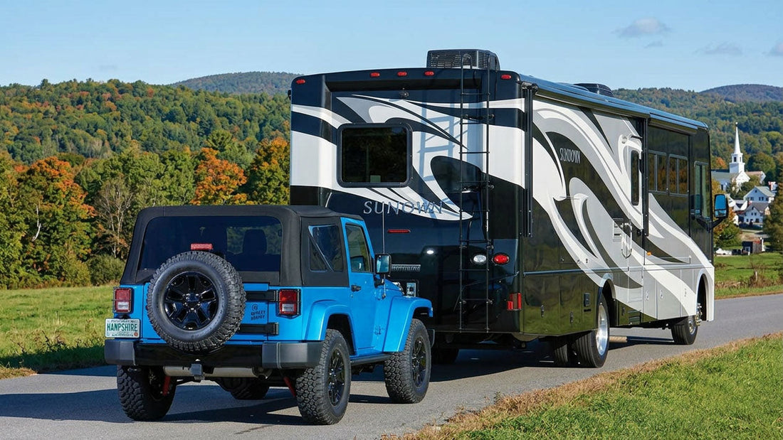 Jeep Wrangler hitched to a tow bar behind a motorhome at a campground