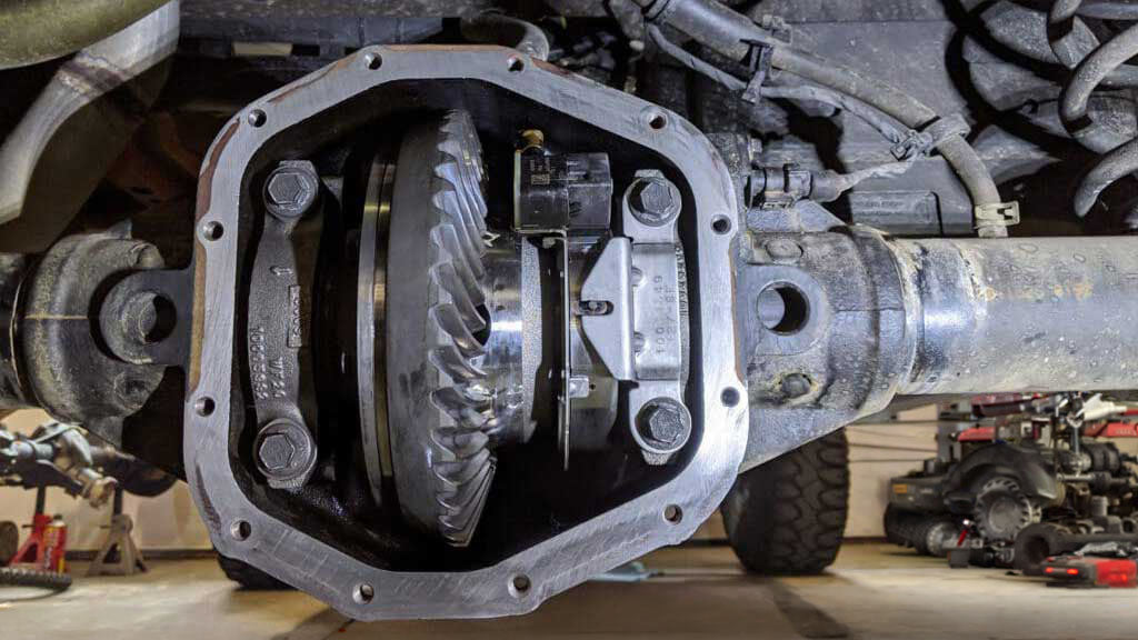 Jeep axle with the differential cover removed, showing the ring gear and carrier inside the housing that set the axle gear ratio