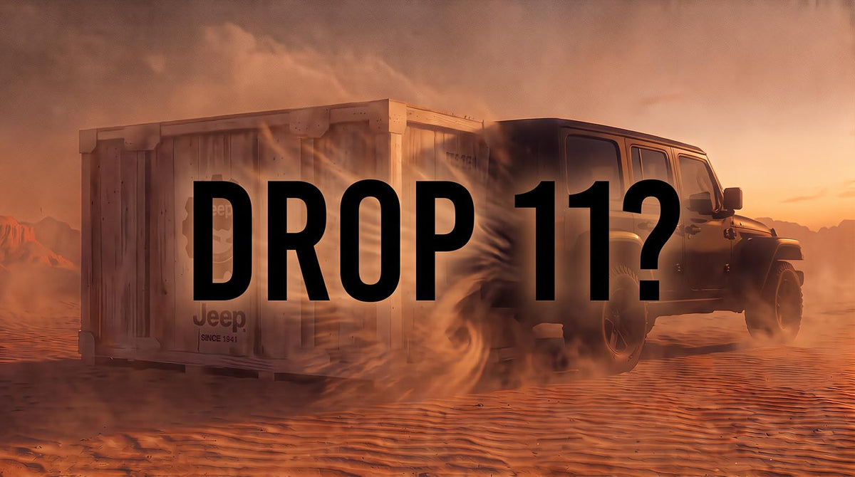 Wooden Jeep shipping crate stamped Jeep Since 1941 sitting in orange desert sand at sunset with a four-door Jeep Wrangler kicking up dust behind it, overlaid with the words Drop 11