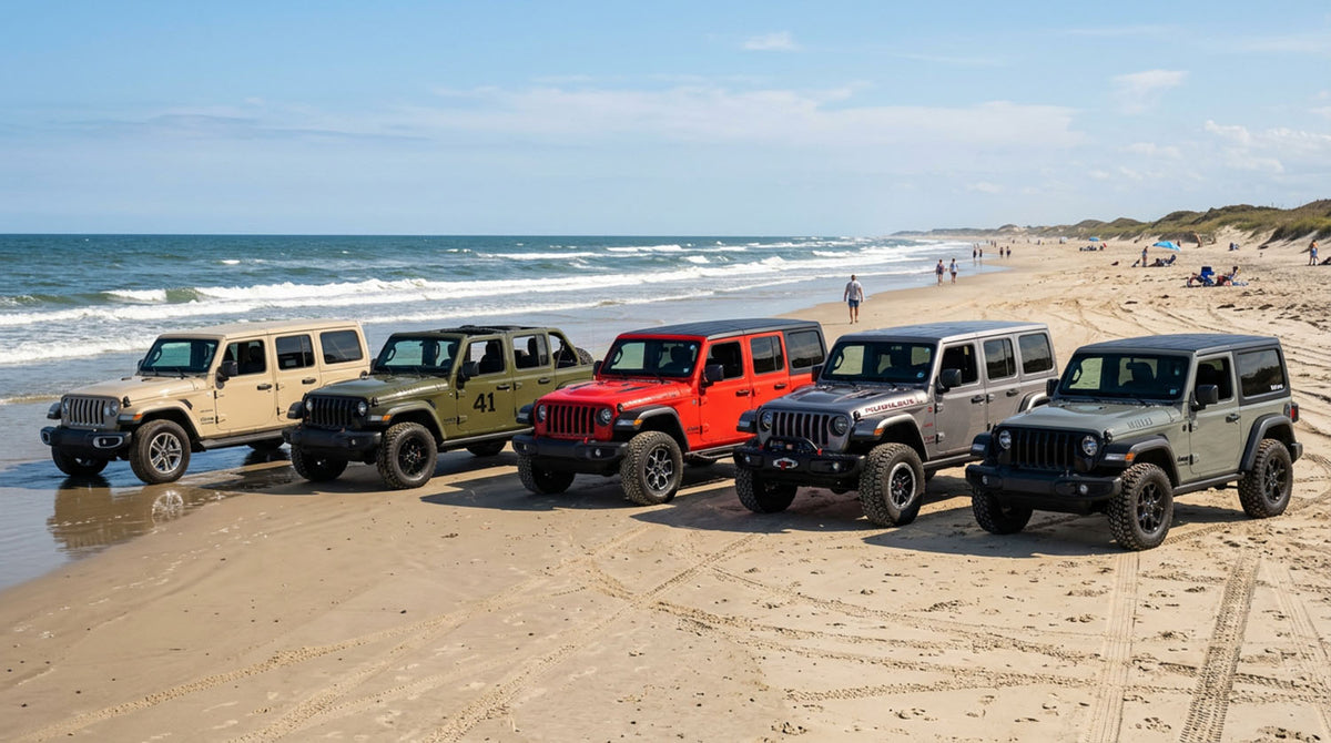 Five Jeep Wrangler JL four-door models in tan, green, red, silver and dark green lined up on a sandy beach