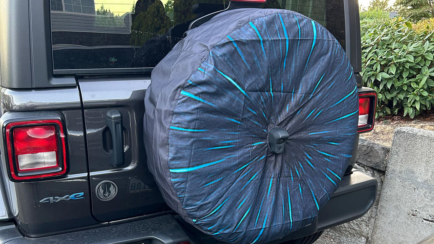 Adventure rigs with covered spare tires, a Jeep with a tailgate spare and an overland trailer with its own covered spare