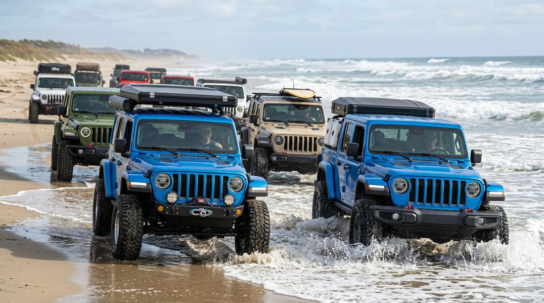 Close up of a convoy of jeep wranglers and gladiators driving on the beach in surf 