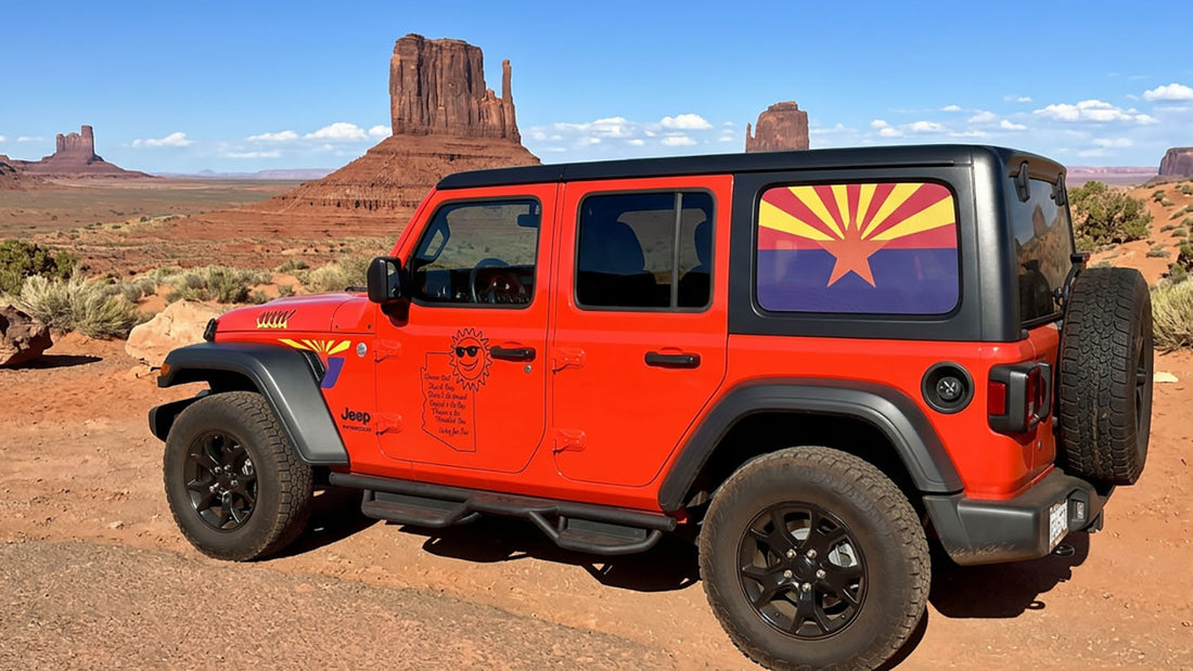 Red Jeep Wrangler with a perforated Arizona flag rear window graphic in the desert