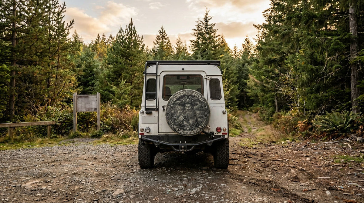 SUV with a rear-mounted spare tire cover parked at a forest trailhead
