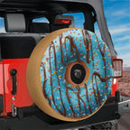 A large, colorful tire cover designed to resemble a donut with sprinkles, mounted on the rear of a red Jeep.