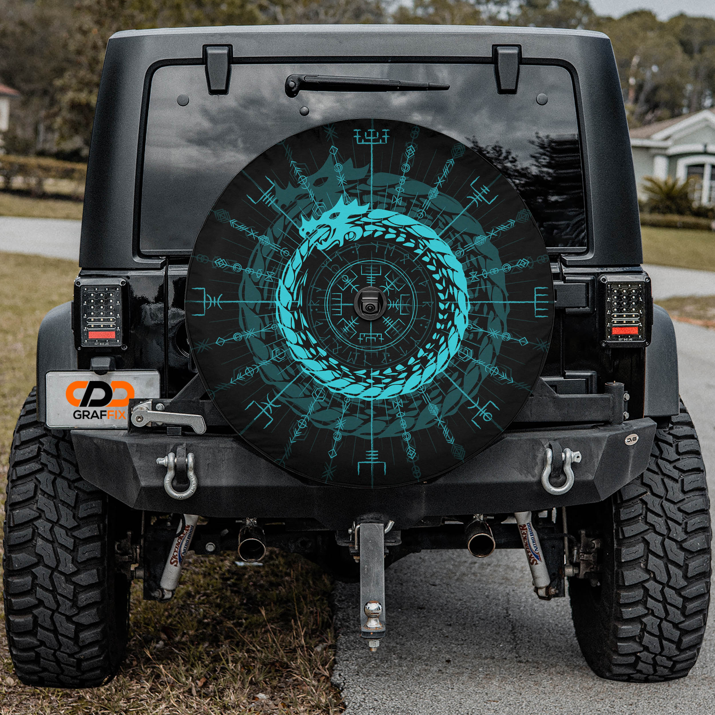 the rear of a black Jeep Wrangler with a large, colorful wheel cover featuring a dragon design.