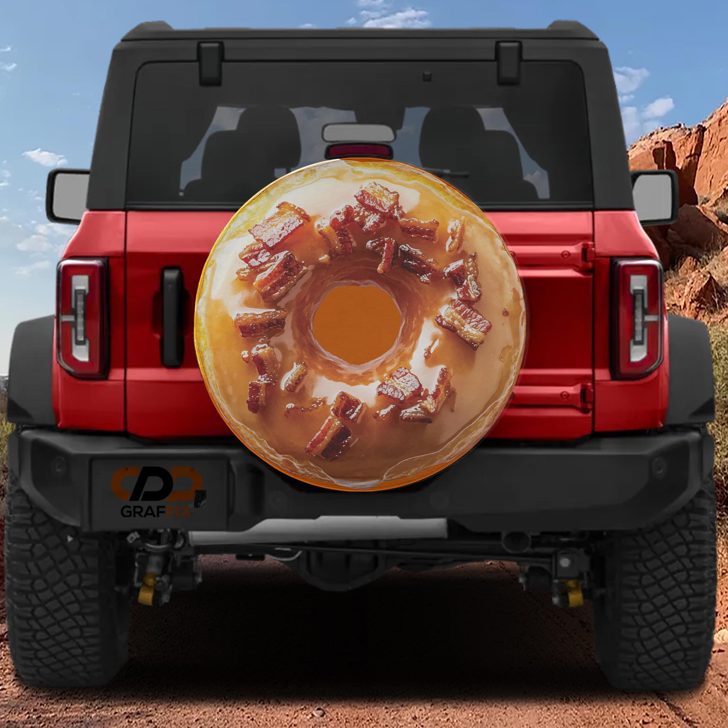 Glazed maple bacon donut spare tire cover on red Ford Bronco showing iced ring topped with chopped bacon bits