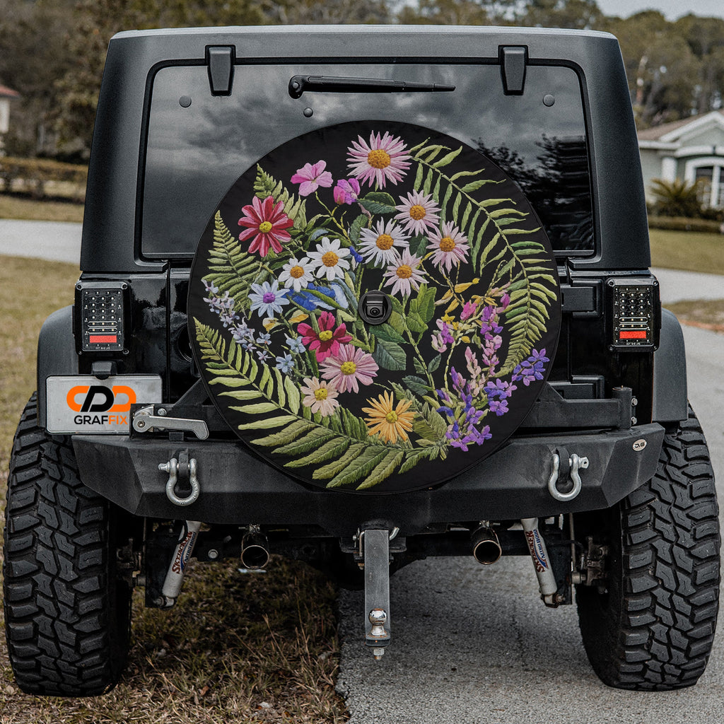 Faux embroidery wildflowers spare tire cover mounted angled view on red SUV outdoors