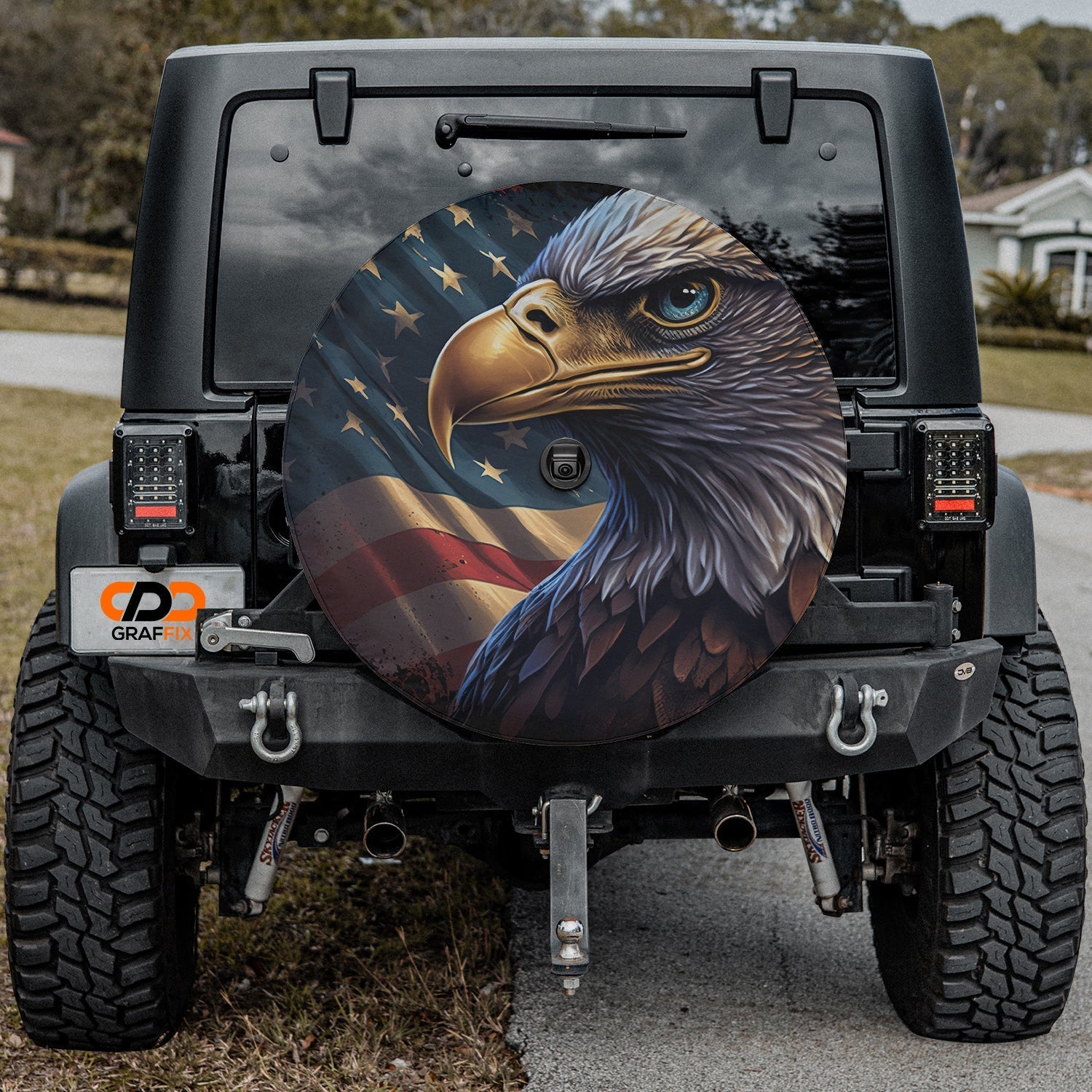Patriotic bald eagle spare tire cover installed on a Jeep Wrangler showing American flag backdrop