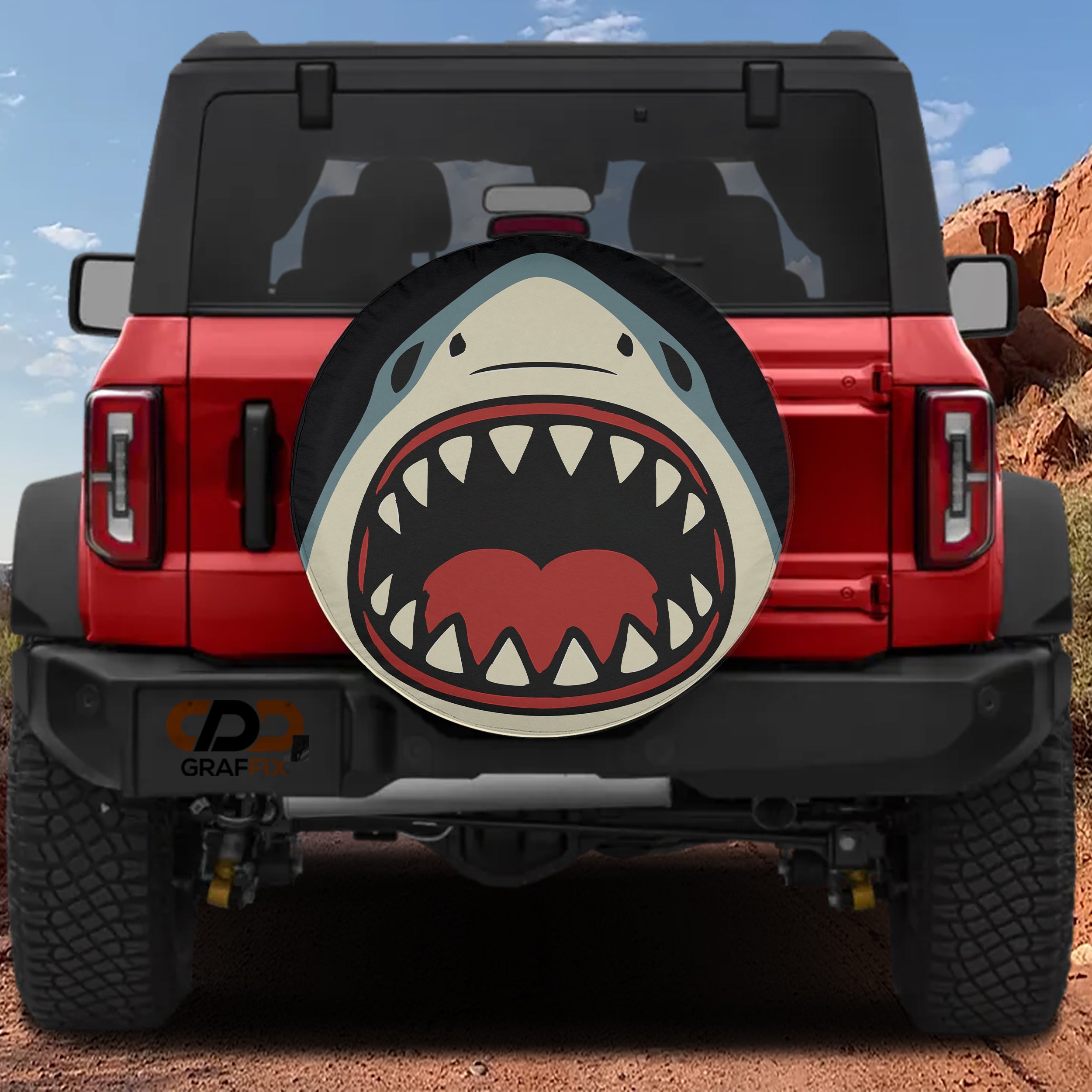 Shark Bite spare tire cover on red Ford Bronco with open jaws teeth cartoon shark design