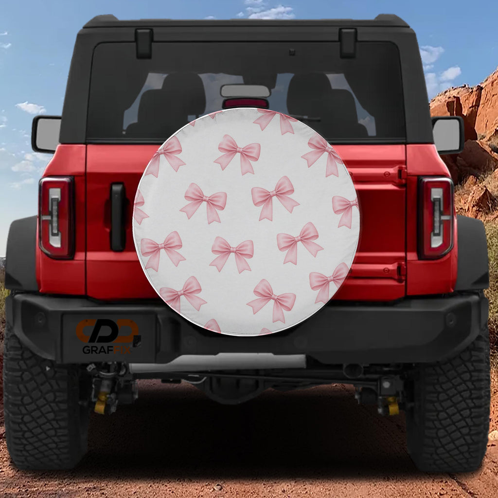 the rear view of a red Jeep Wrangler with a decorative white and pink bow pattern on the rear window.