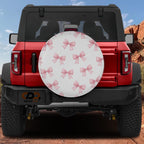 the rear view of a red Jeep Wrangler with a decorative white and pink bow pattern on the rear window.