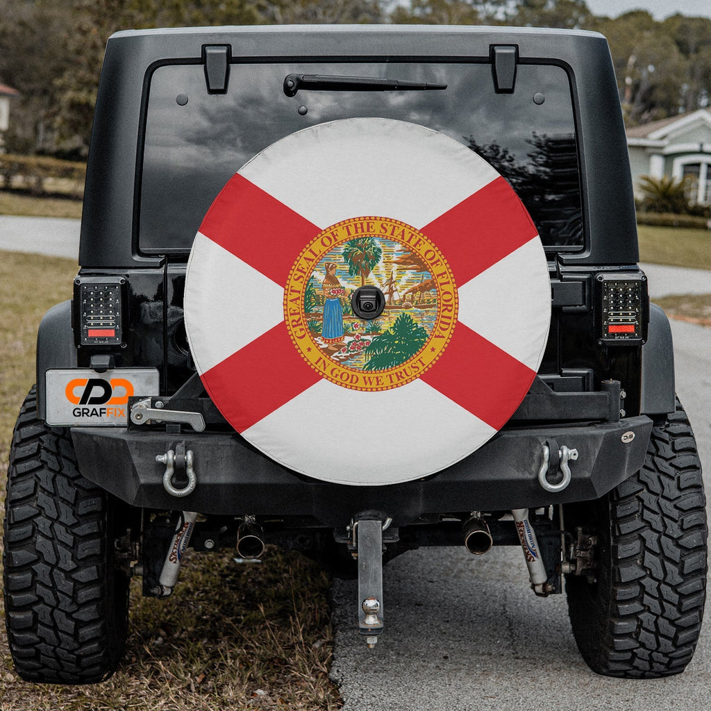 Florida state flag spare tire cover on black Jeep Wrangler with Graffix plate featuring red cross and state seal