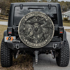 a black Jeep Wrangler with a large, detailed, pirate-themed wheel cover on the rear of the vehicle.