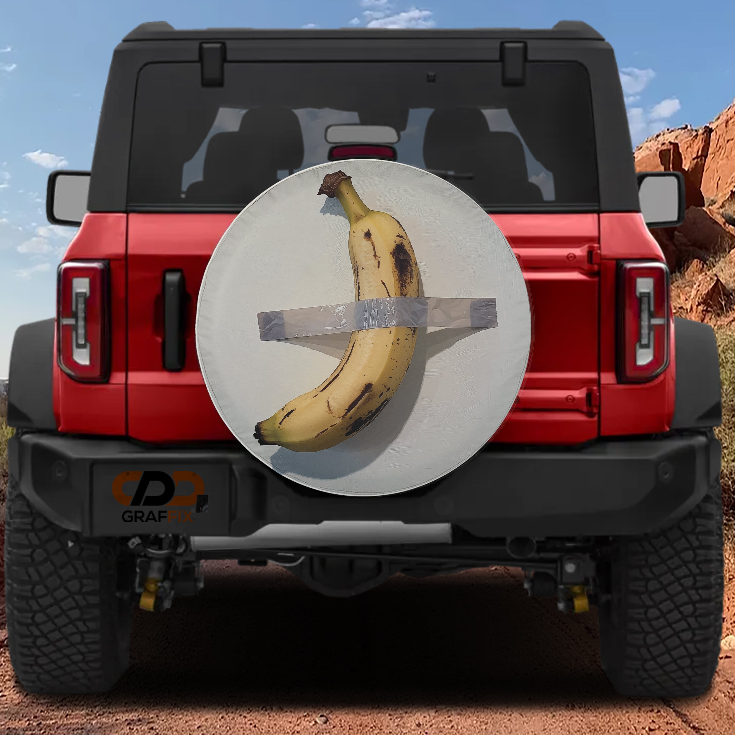 Duct-Taped Banana spare tire cover with art parody design shown on red Bronco CDD GRAFFIX badge