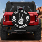 a red Jeep Wrangler with a wheel cover that says "Have the day, you deserve" and has a skull and crossbones design.