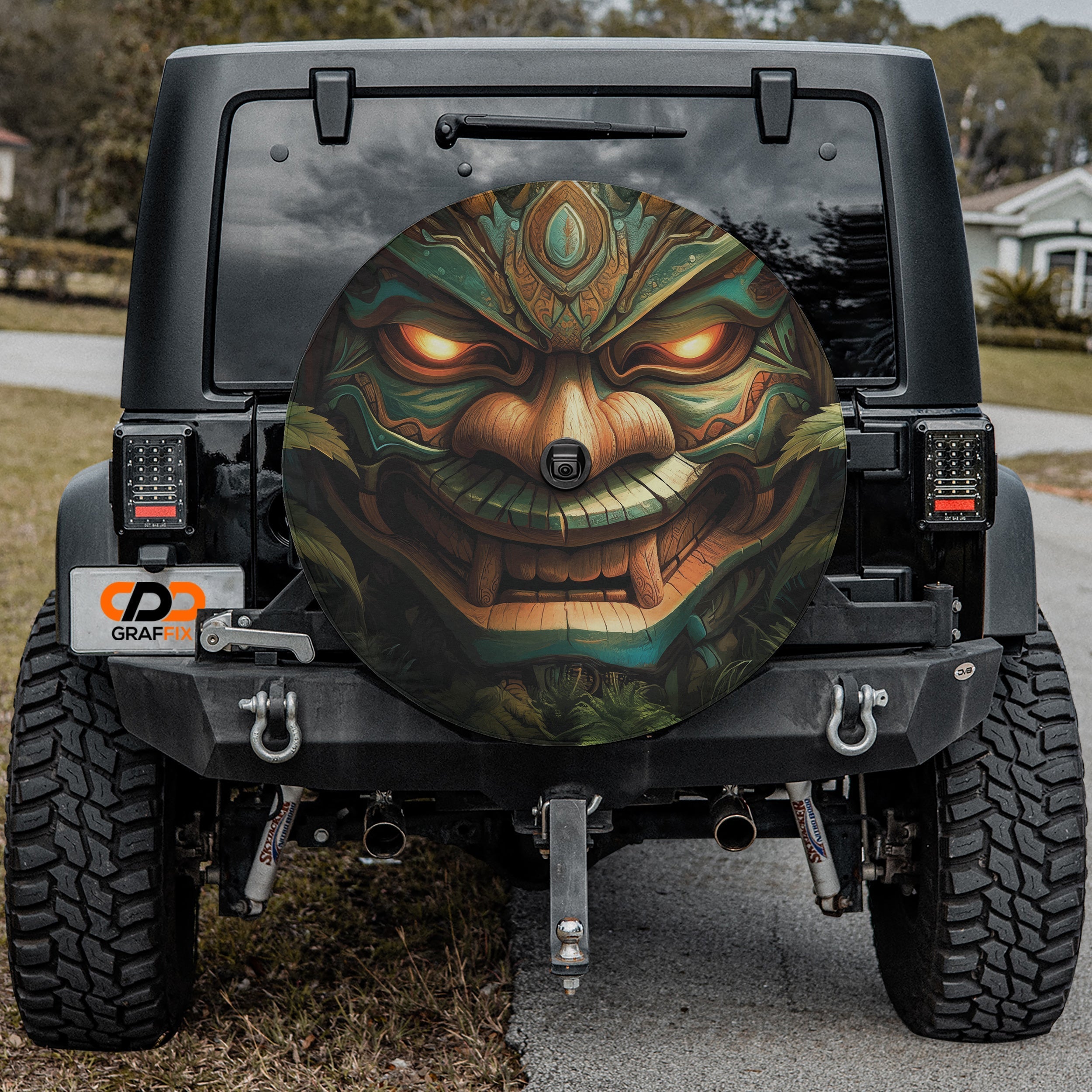 Tiki Totem of Fury spare tire cover rear angle on red Jeep featuring tribal wooden warrior face