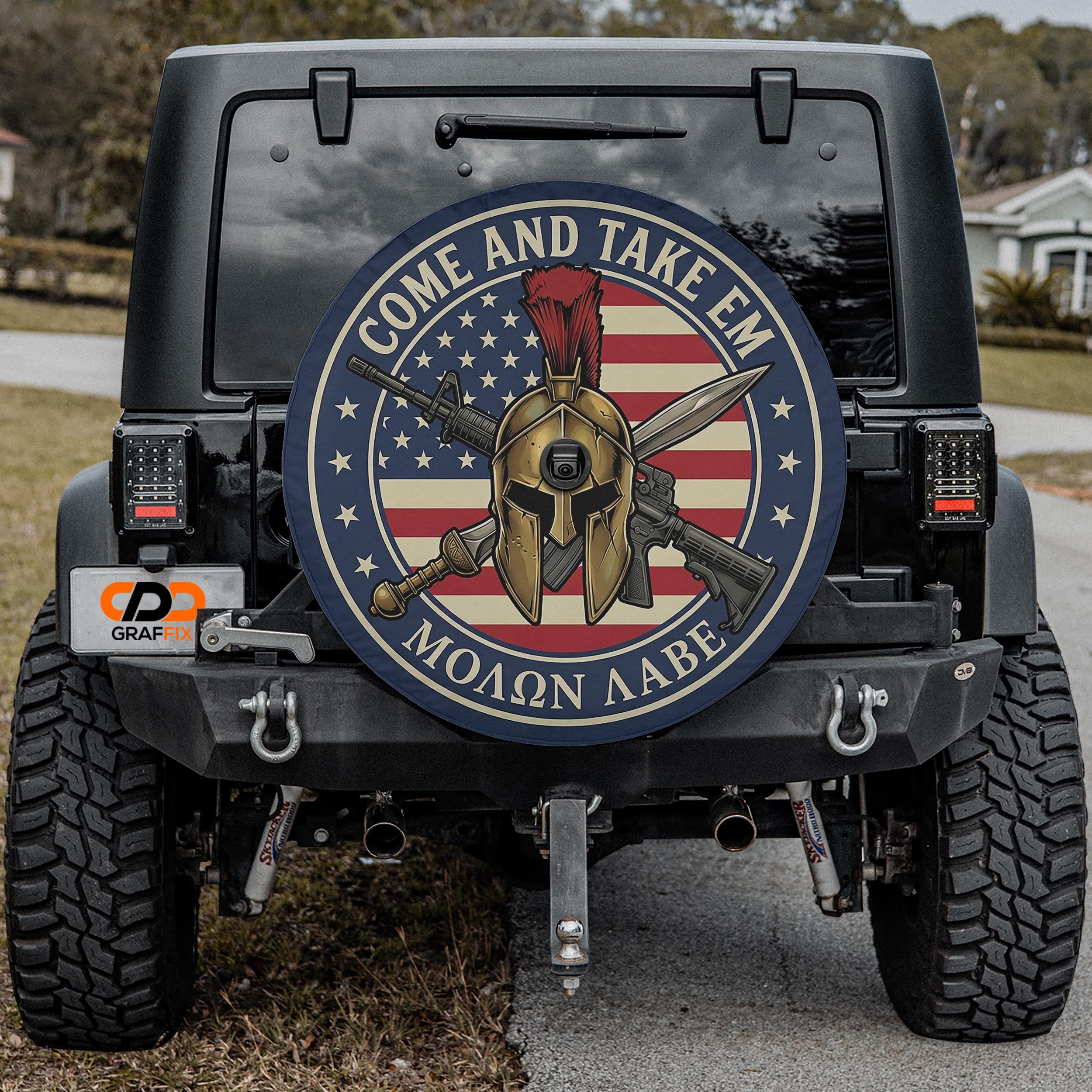 the back of a black Jeep Wrangler with a large American flag-themed wheel cover featuring a helmet and crossed swords.