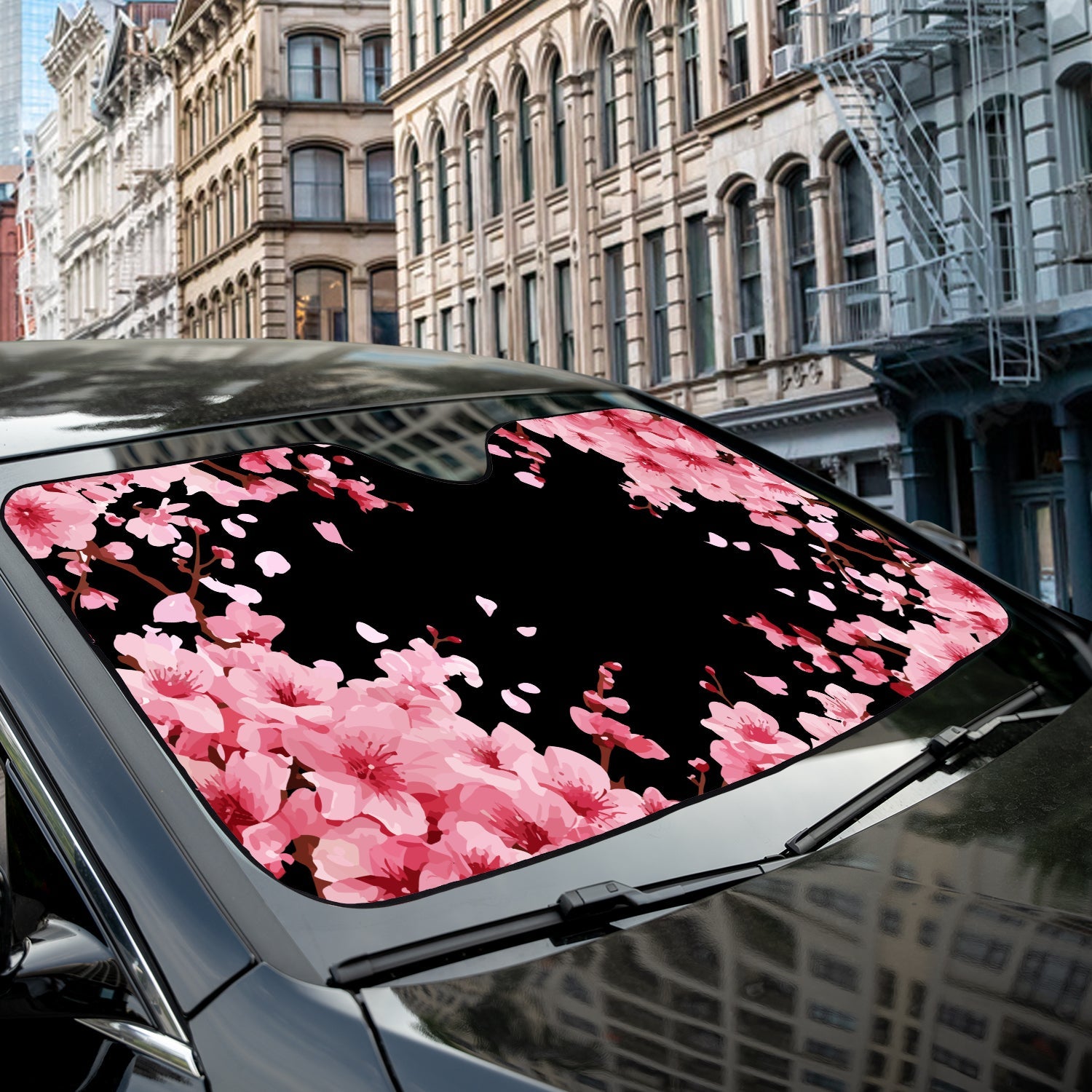 Japanese Cherry Blossom accordion sunshade close-up installed on a dark sedan windshield exterior detail