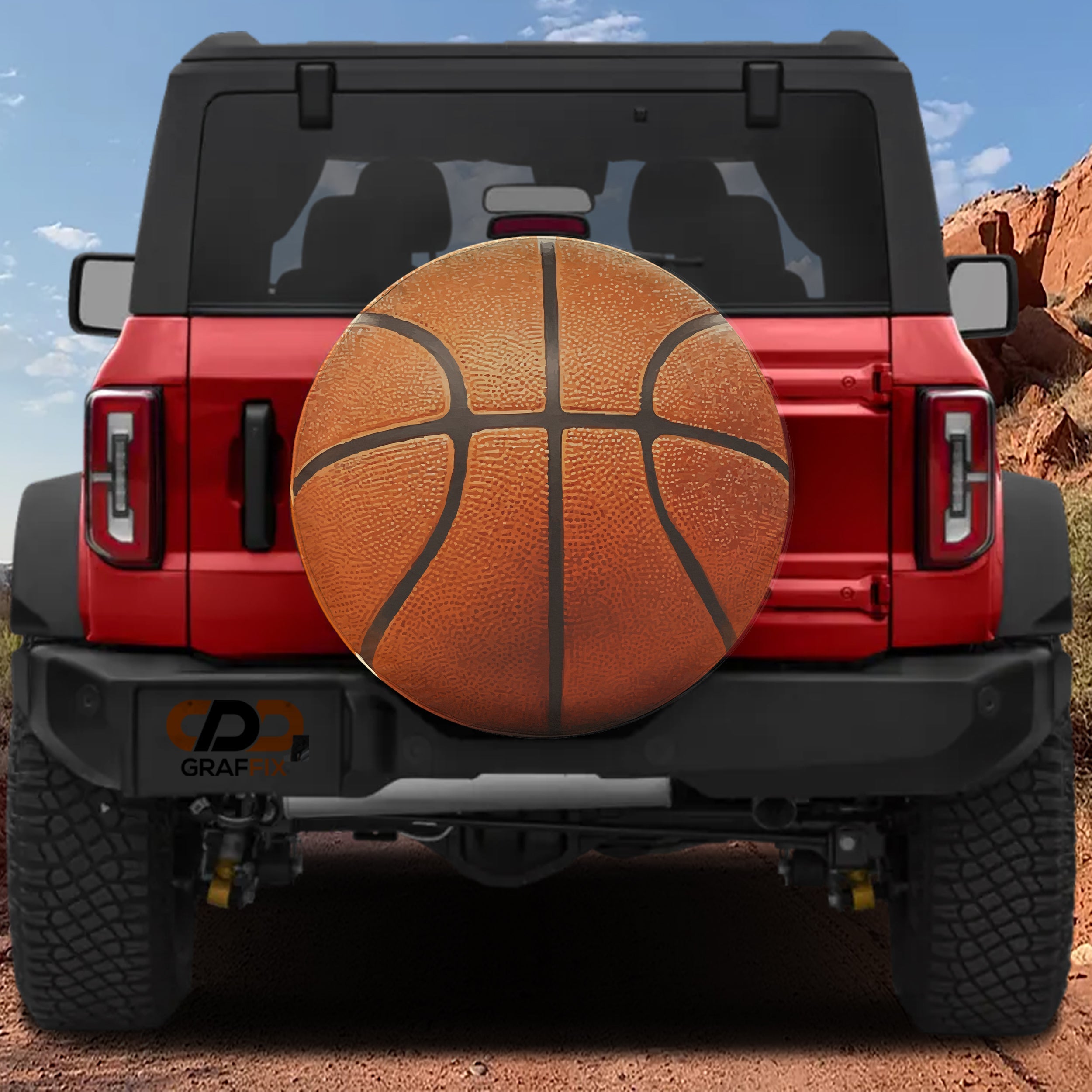 Basketball spare tire cover rear angle view on parked Jeep with backup camera cutout
