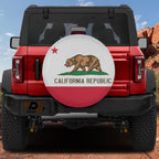 California Republic state flag spare tire cover mounted on red Ford Bronco rear with red rock canyon backdrop