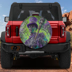 a red Jeep Wrangler with a large, colorful wheel cover depicting a character with a skull and crossbones design.