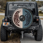 the back of a black Jeep Wrangler with a large, decorative wheel cover featuring a design of two stylized birds.