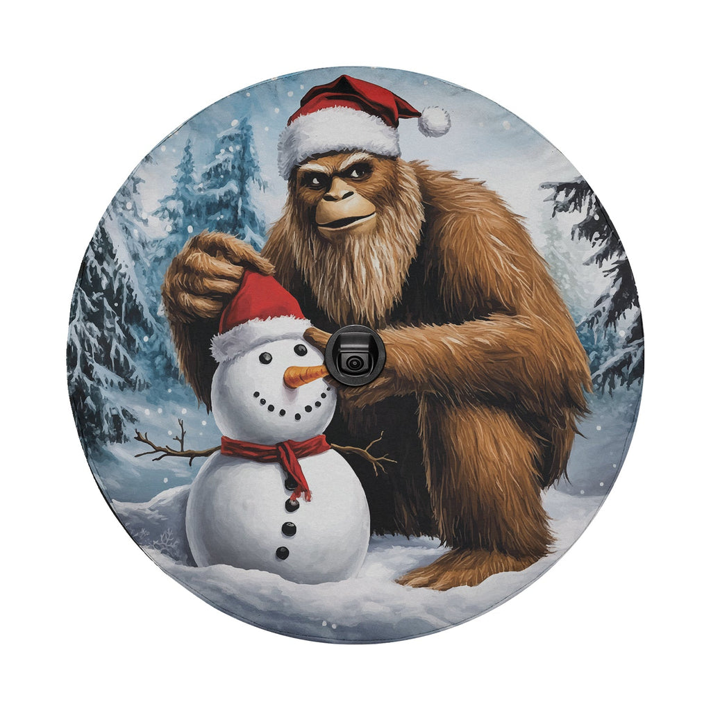 Bigfoot Sasquatch with Santa hat building snowman round tire cover art and central camera cutout