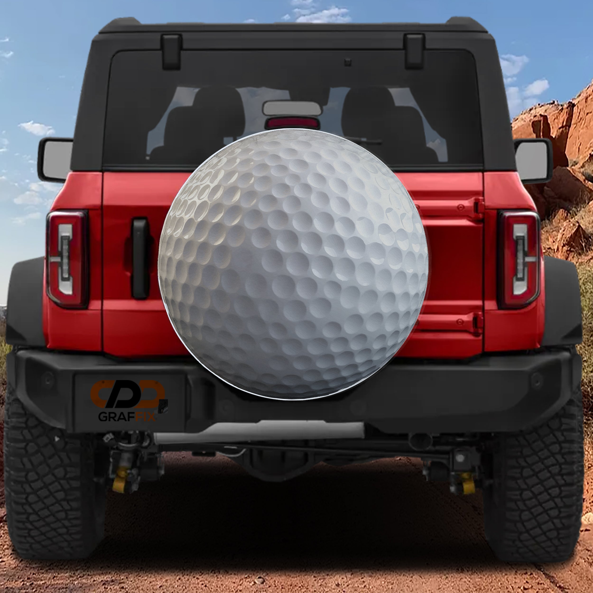 Golf ball spare tire cover rear angle view on parked Jeep with backup camera cutout