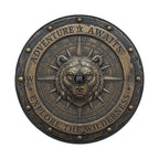 a metal compass with a bear's head at the center, surrounded by the words "Adventure Awaits" and "Exploration the Wilderness".