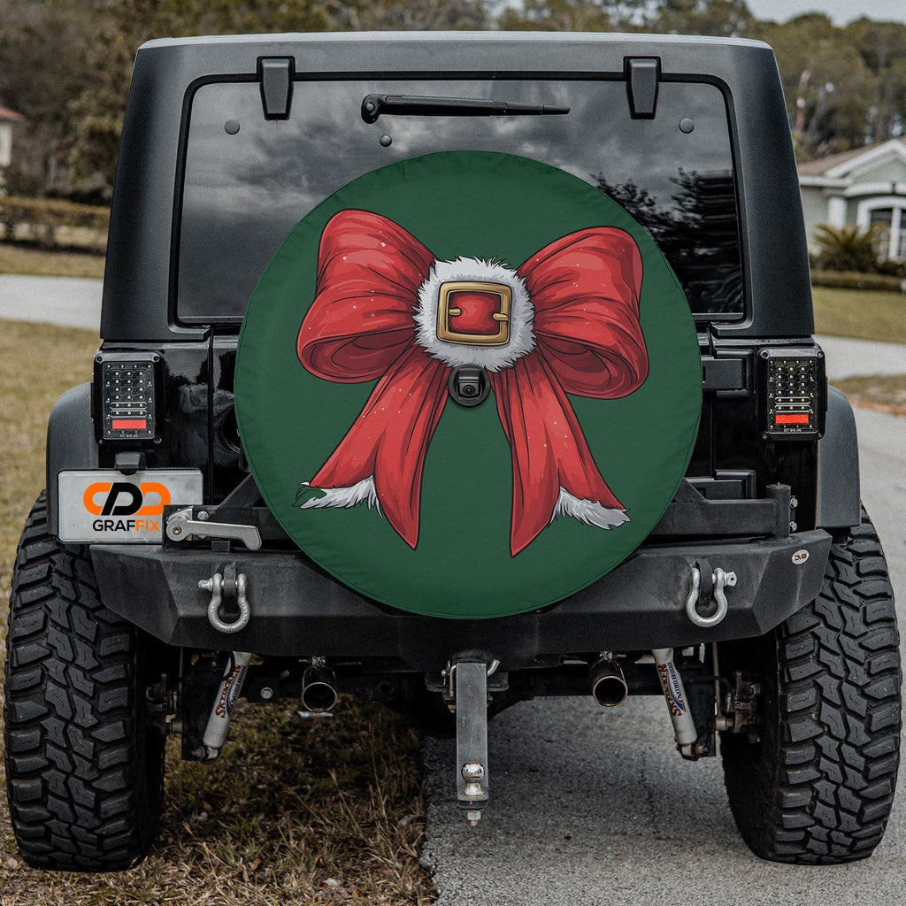 Coquette Santa bow tire cover mounted on black Jeep Wrangler with green ribbon and Santa belt design