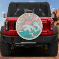 Here Comes the Sun spare tire cover on red Ford Bronco with retro pink sun and teal waves