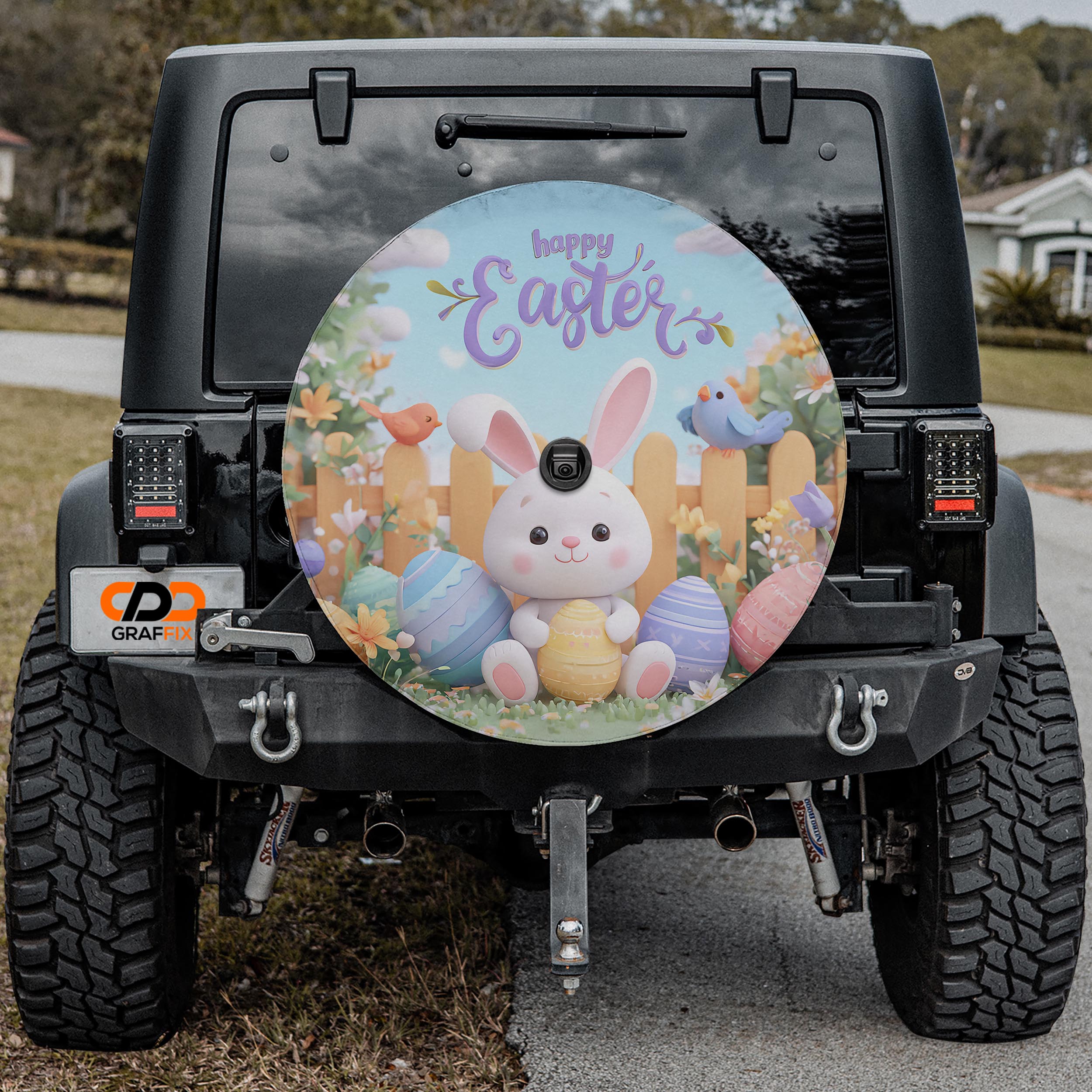 a black Jeep Wrangler with a large Easter-themed wheel cover attached to the rear.