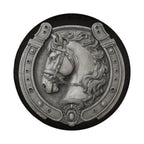 A decorative relief of a horse's head in a horseshoe-shaped frame.