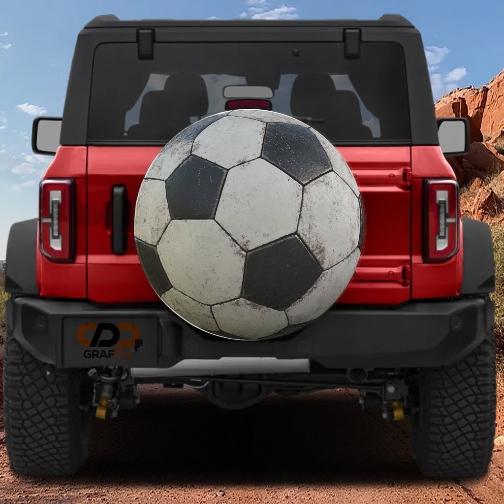 Soccer ball spare tire cover rear angle view on parked Jeep with backup camera cutout