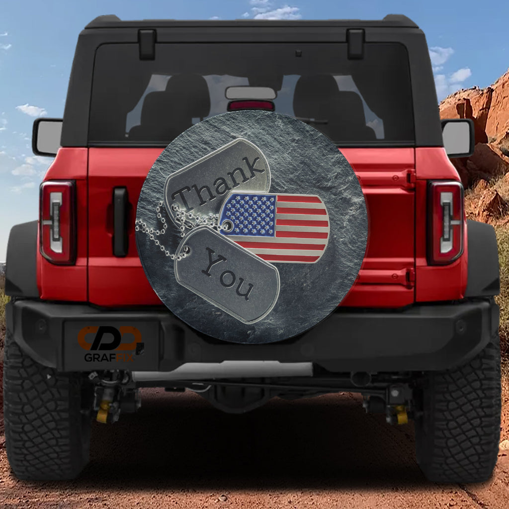 Flat veterans tribute spare tire cover artwork featuring dog tags, US flag and Thank You message on stone