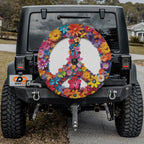 Black Jeep Wrangler rear with daisy peace symbol tire cover and GRAFFIX badge plate on suburban street