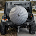 Golf ball white dimpled spare tire cover mounted on black Jeep Wrangler rear outdoors