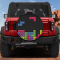 Pixel block puzzle spare tire cover on red Ford Bronco showing colorful Tetris-style brick stacking design