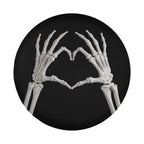 A pair of white skeletal hands forming a heart shape against a black background.