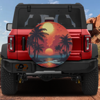 Scarlet horizon palm tree sunset tire cover on red Ford Bronco showing orange beach silhouette scene