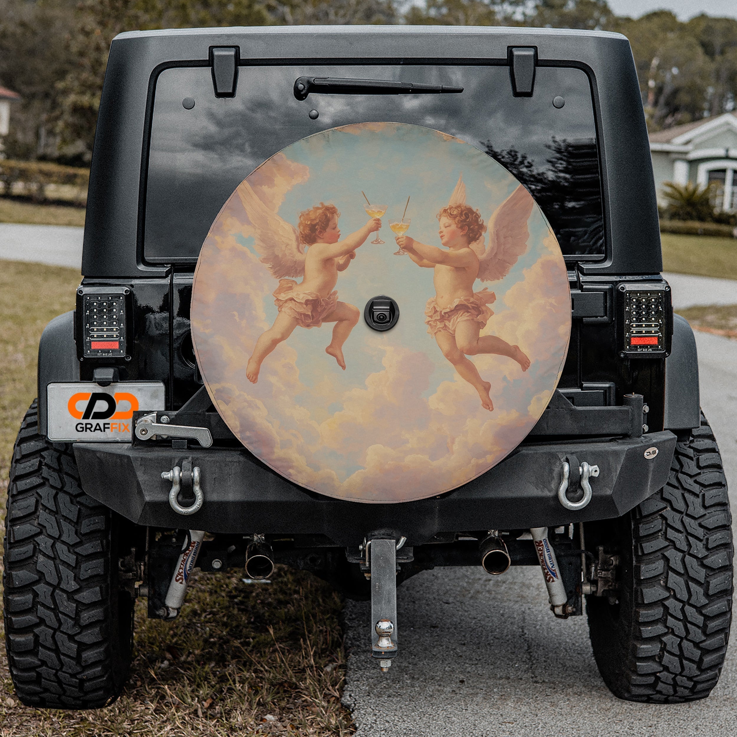 Angels' Toast spare tire cover with cherubs design mounted on black Jeep Wrangler tailgate