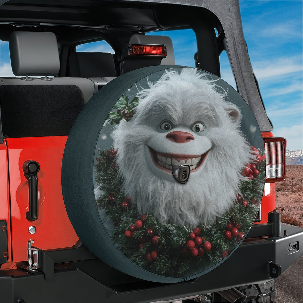 Cheerful yeti and holly spare tire cover displayed on the rear of a Jeep Wrangler with mountains