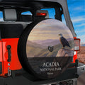 Acadia National Park spare tire cover with a bald eagle on a cliff at sunrise, mounted with a backup camera port on a red Jeep Wrangler