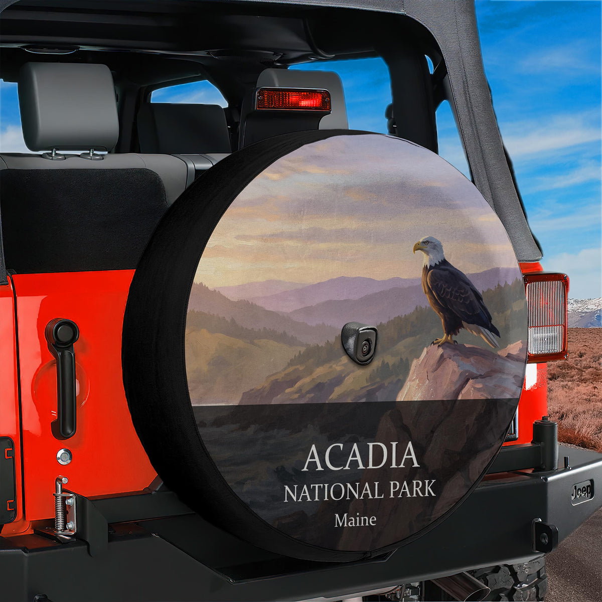Acadia National Park spare tire cover with a bald eagle on a cliff at sunrise, mounted with a backup camera port on a red Jeep Wrangler