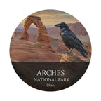Arches National Park spare tire cover without a camera hole, showing a raven on a sandstone ledge beside Delicate Arch