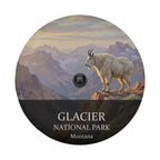 Glacier National Park spare tire cover with a backup camera hole, showing a mountain goat on a ledge above glacier-carved peaks