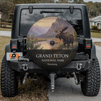 Grand Teton National Park spare tire cover on a Jeep Wrangler, showing a bull moose by a river below the Teton range