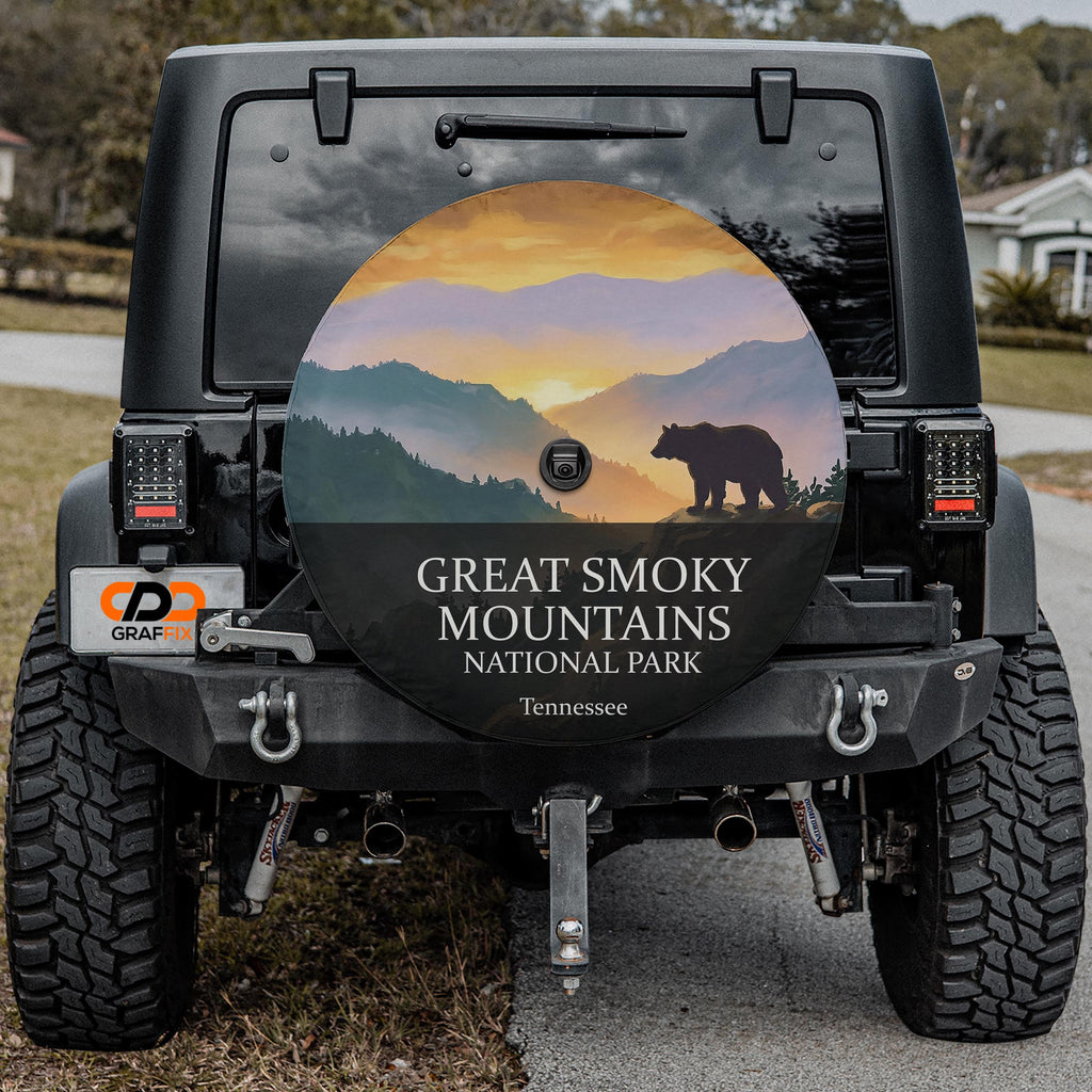 Great Smoky Mountains National Park spare tire cover on a Jeep Wrangler, showing a black bear silhouette on a ridge above layered blue ridgelines
