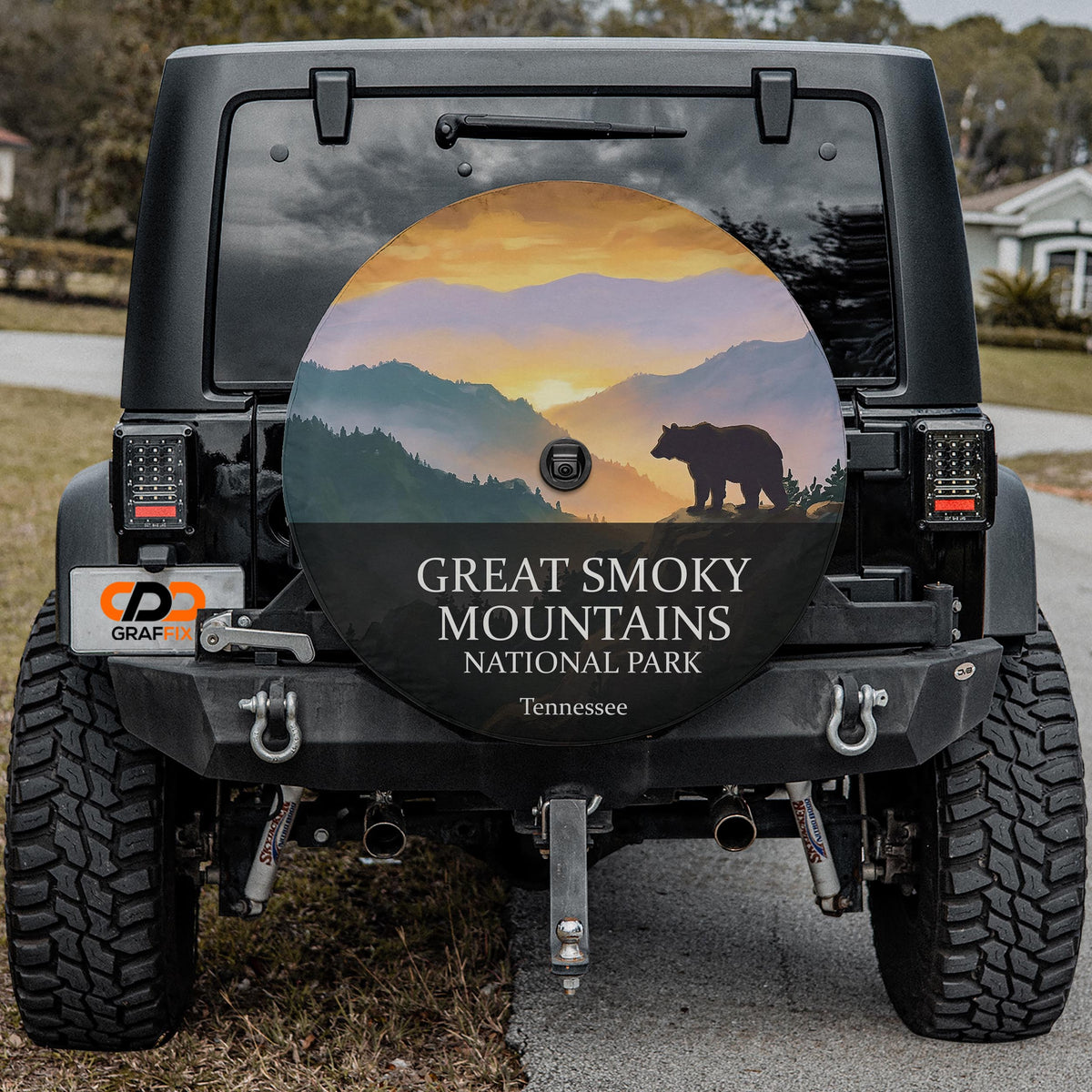 Great Smoky Mountains National Park spare tire cover on a Jeep Wrangler, showing a black bear silhouette on a ridge above layered blue ridgelines